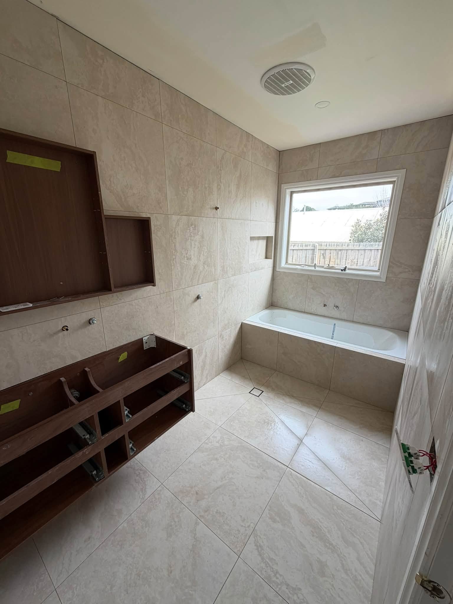Travertine-look wall and floor tiling in a Sydney bathroom